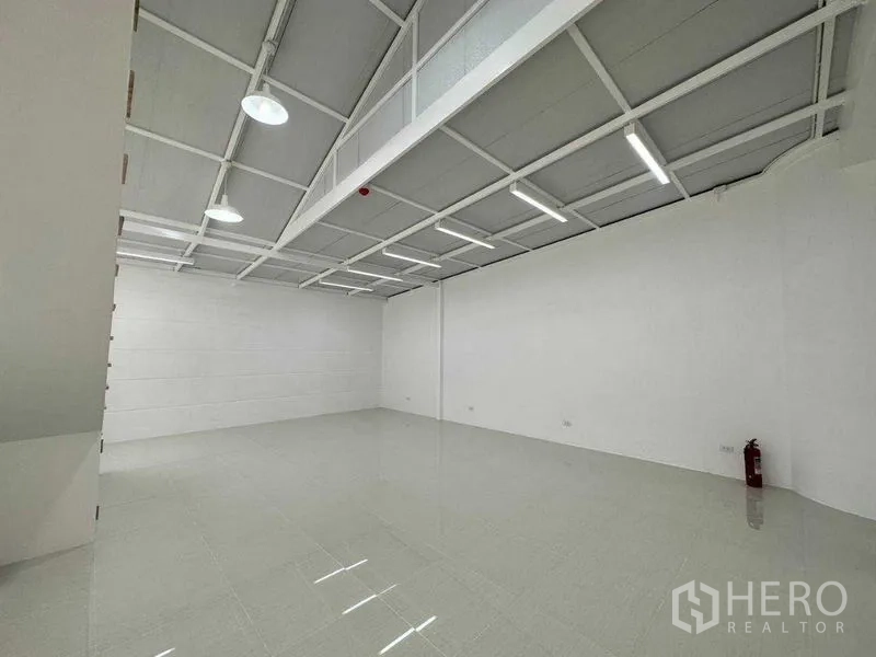 办公空间 出租或出售在Khlong Toei, Bangkok - 开放式白色办公层，亮面瓷砖地、LED灯带与灭火器。