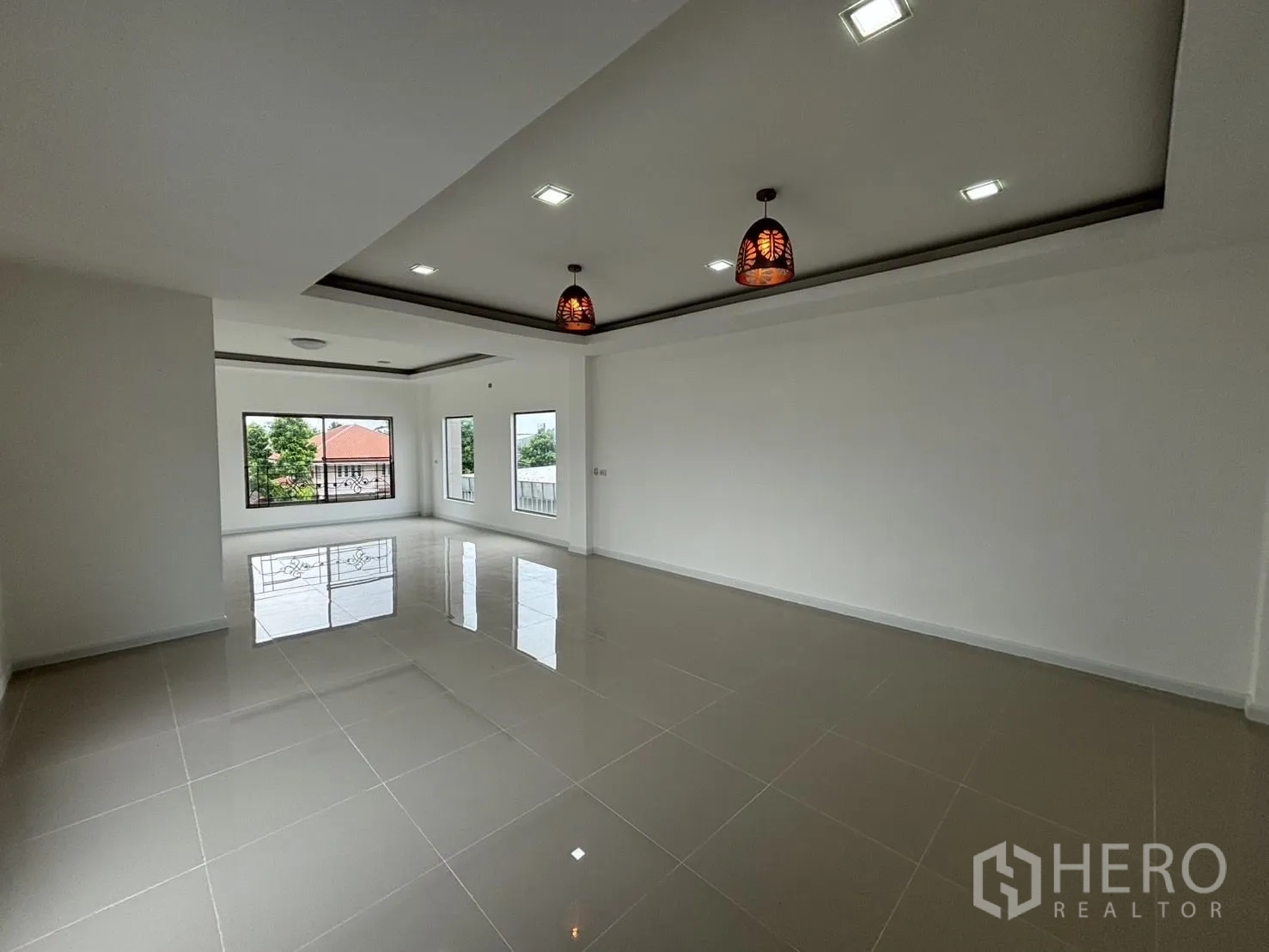 Warehouse for rent or sale in Wang Thonglang, Bangkok - Large living or office area with windows and pendant lights.