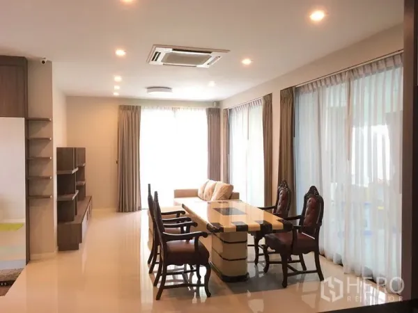 Detached House for rent or sale in Bang Kapi, Bangkok - Open-plan living and dining area with large windows and recessed lighting.