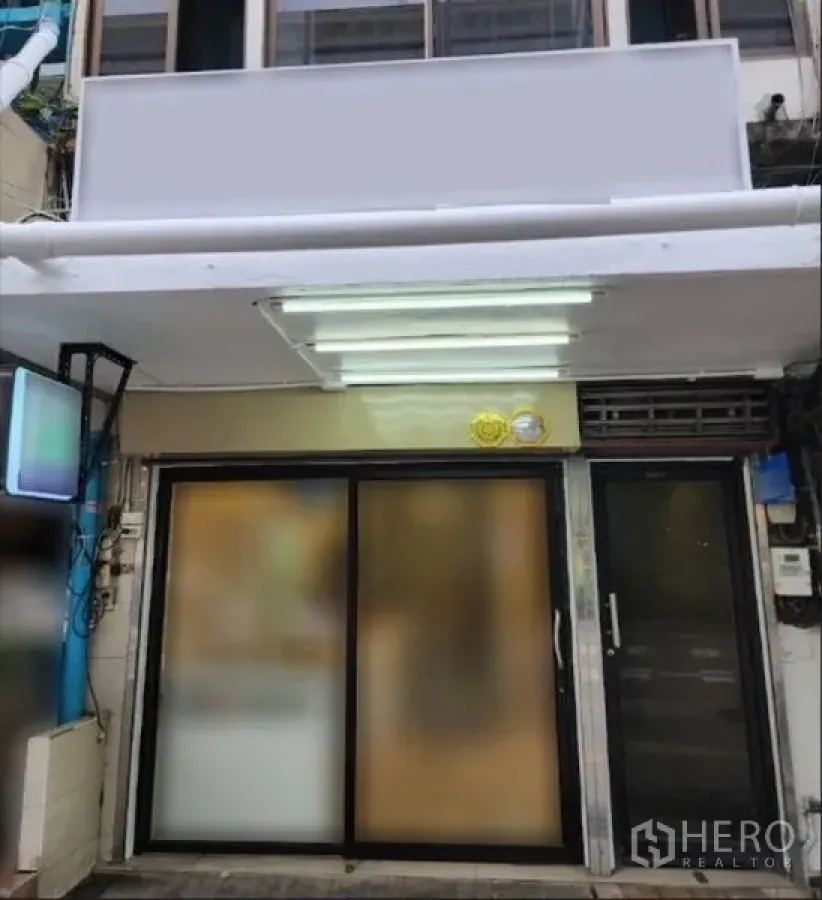 Retail Space for rent in Khlong Toei, Bangkok - Retail unit facade with large signboard and illuminated canopy above sliding doors.
