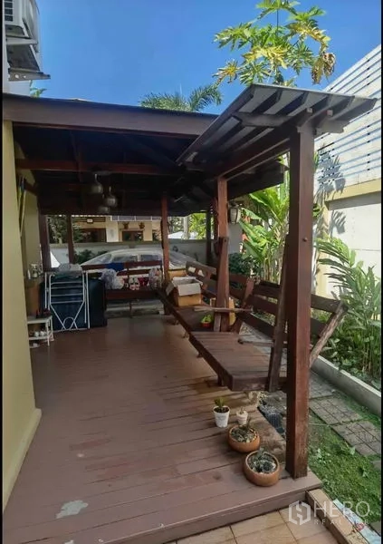 Detached House for sale in Bang Yai, Nonthaburi - Covered wooden terrace with bench seating beside the garden.