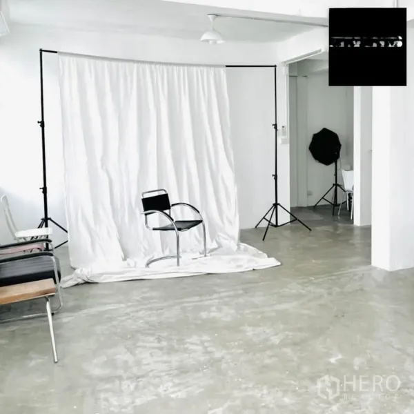 Shophouse for rent in Phra Khanong, Bangkok - White studio room with photography backdrop, tripods, and polished concrete floor.