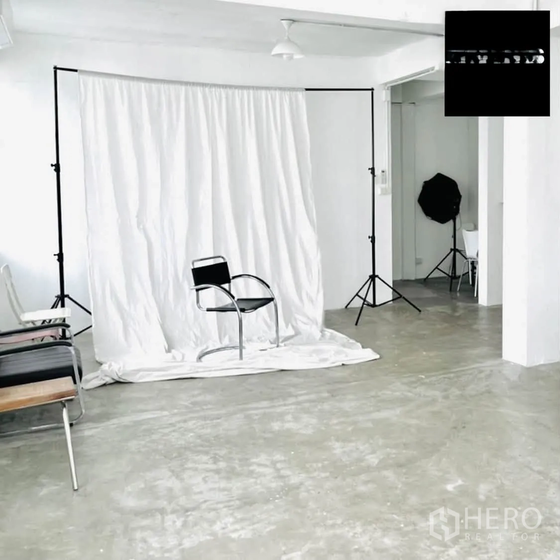 Shophouse for rent in Phra Khanong, Bangkok - White studio room with photography backdrop, tripods, and polished concrete floor.