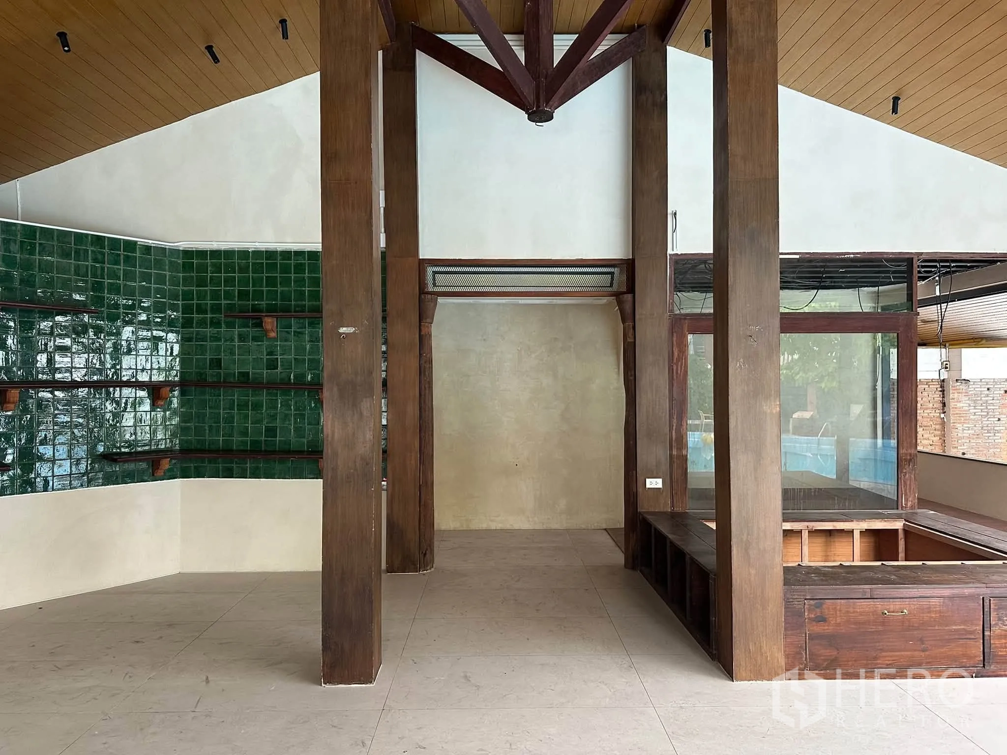 Retail Space for rent in Khlong Toei, Bangkok - Open-plan area featuring wooden columns, vaulted ceiling, green tile wall, and display counter.