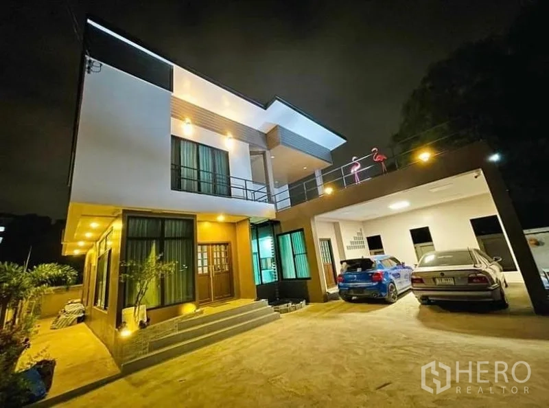 独立式住宅 出售在Sai Mai, Bangkok - 夜景现代两层独栋住宅，外立面灯光柔和并设有有顶车位。