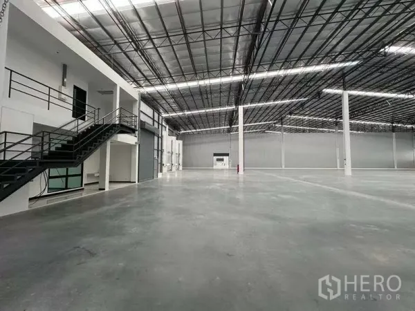 货栈 出租在Chon Buri - 仓库内部设夹层办公室、楼梯与卷帘门。