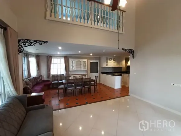 Detached House for rent in Mueang Samut Prakan, Samut Prakan - Open-plan living and dining space facing the kitchen, terracotta floors and mezzanine railing.