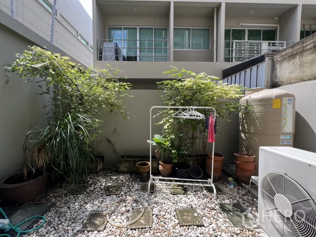 Townhouse for rent in Suan Luang, Bangkok - Narrow water feature beside a glass wall leading to the pool zone.