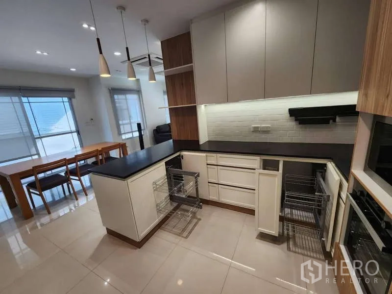 Detached House for rent in Sathon, Bangkok - Kitchen perspective with pull-out drawers and view toward the dining area.