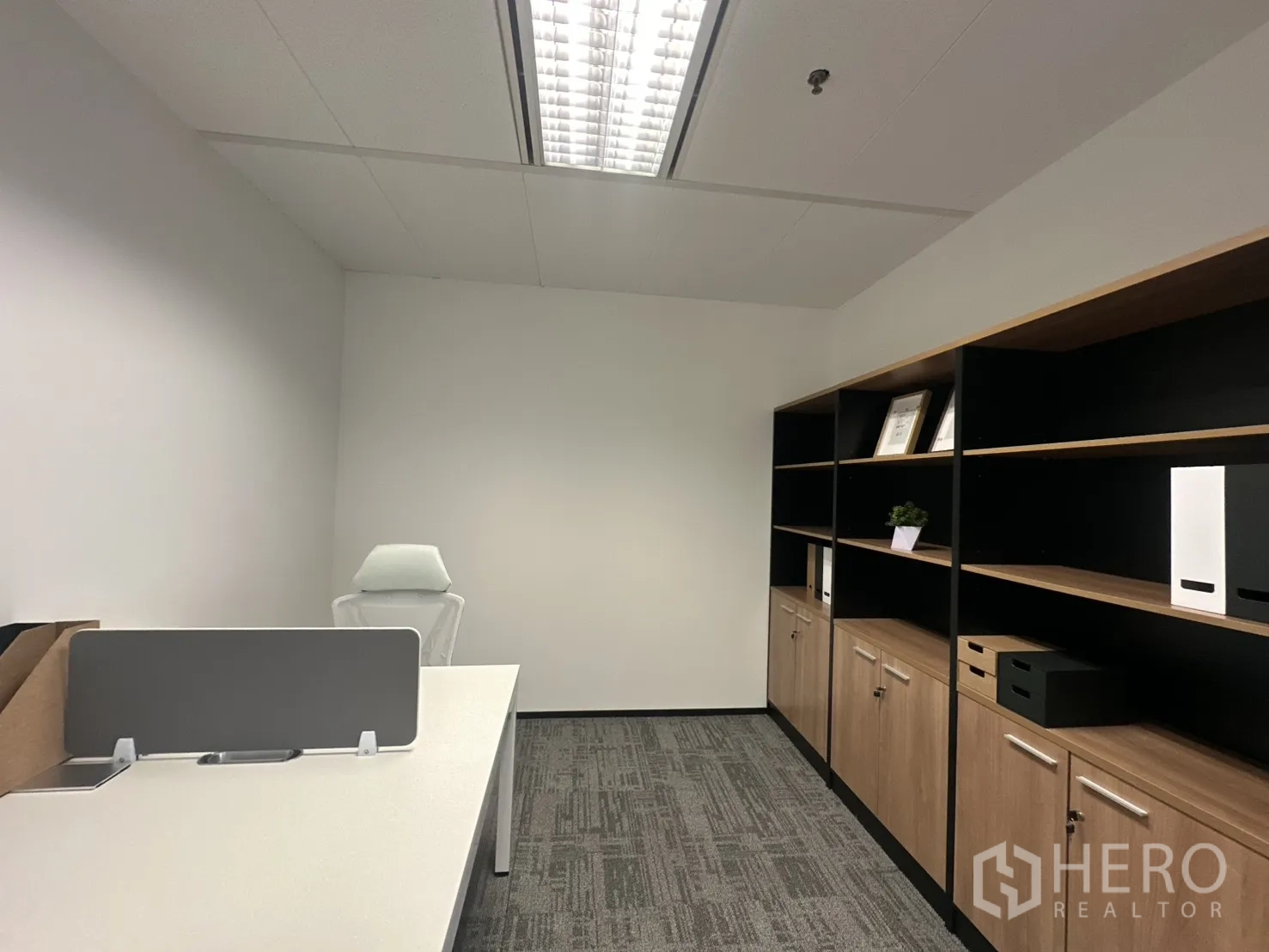 Office Space for rent in Pathum Wan, Bangkok - Small private office with desk and wall-length storage shelves.