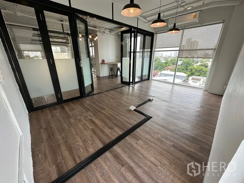 Office Space for rent in Watthana, Bangkok - Glass-walled meeting rooms and large windows with roller blinds, overlooking greenery and the city skyline.