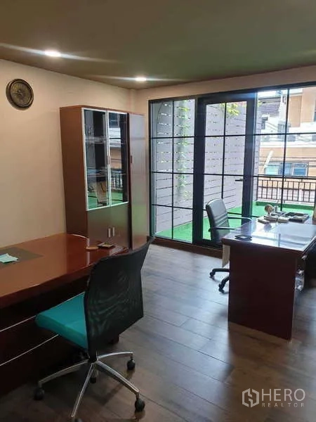 Home Office for rent in Khlong Toei, Bangkok - Bright office room with desks facing large sliding glass doors to a balcony.