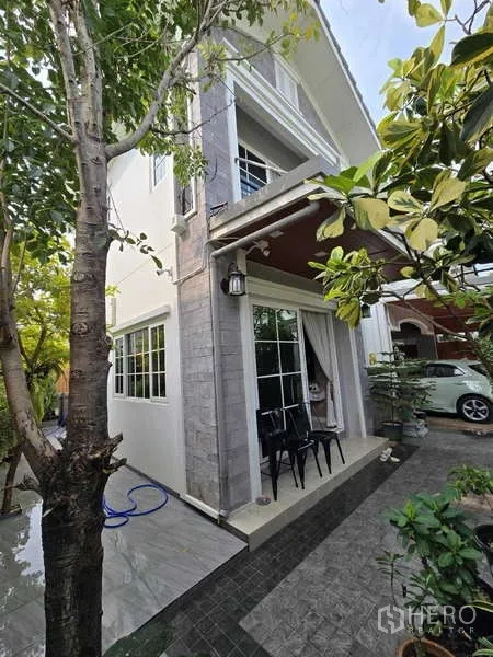 Detached House for rent in Thanyaburi, Pathum Thani - Another view of the two-storey exterior with patio and trees around the home.
