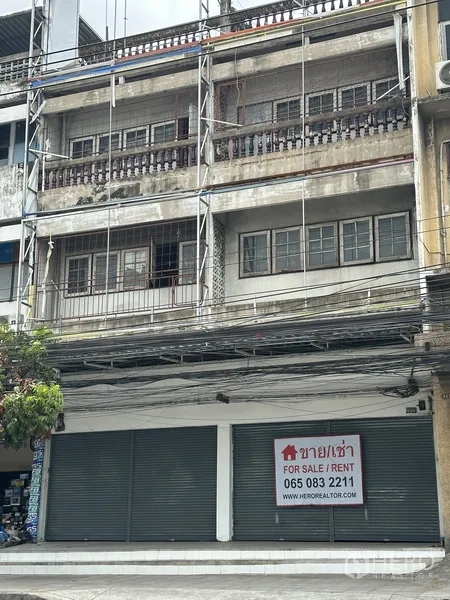 Shophouse for rent or sale in Watthana, Bangkok - Multi-storey shophouse facade with twin roller shutters and a For Sale/Rent sign.