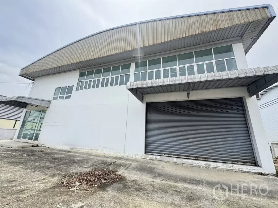 Warehouse for sale in Mueang Samut Prakan, Samut Prakan - Front view of a standalone warehouse with large roller shutter door and clerestory windows in Bang Pu.