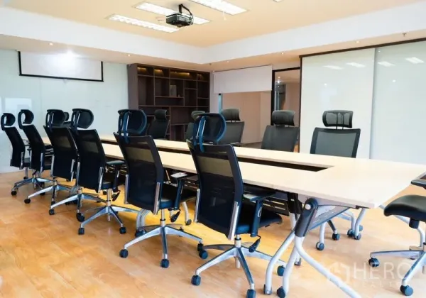 Office Space for rent - Spacious boardroom with long conference table, executive chairs and ceiling projector.