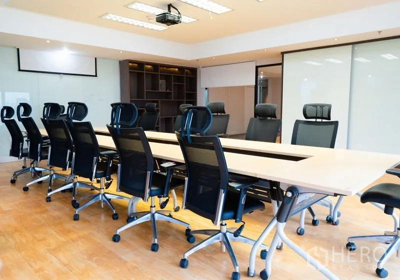 Office Space for rent - Spacious boardroom with long conference table, executive chairs and ceiling projector.