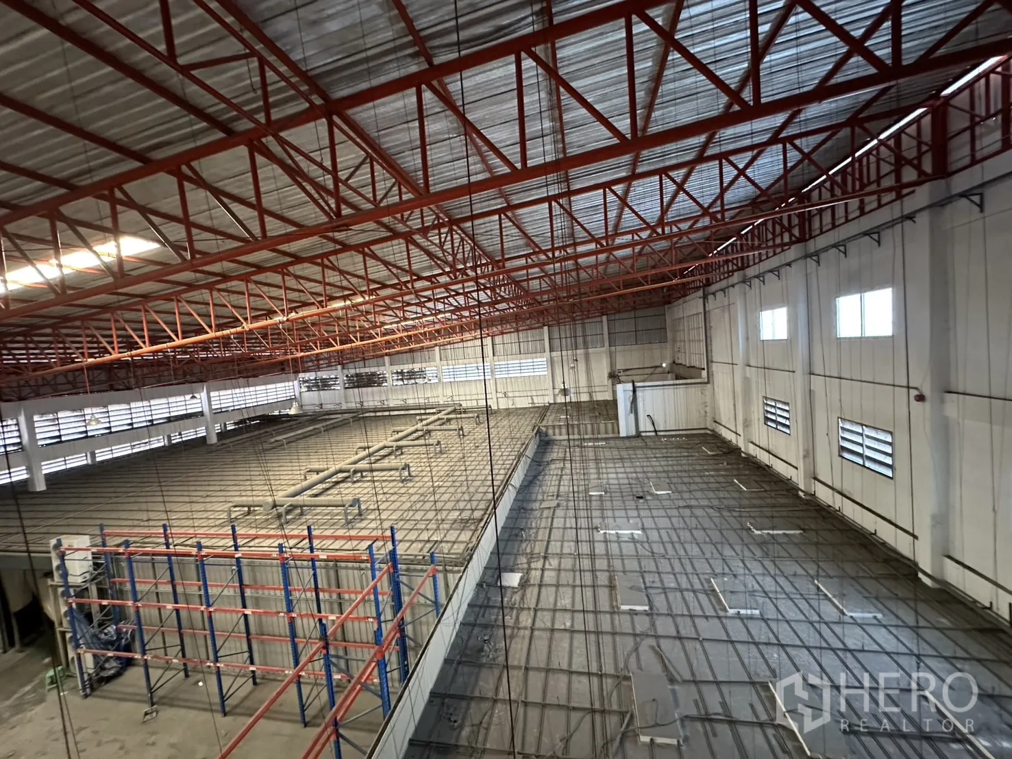 Factory for rent - View of suspended grid above the production mezzanine and steel roof trusses.