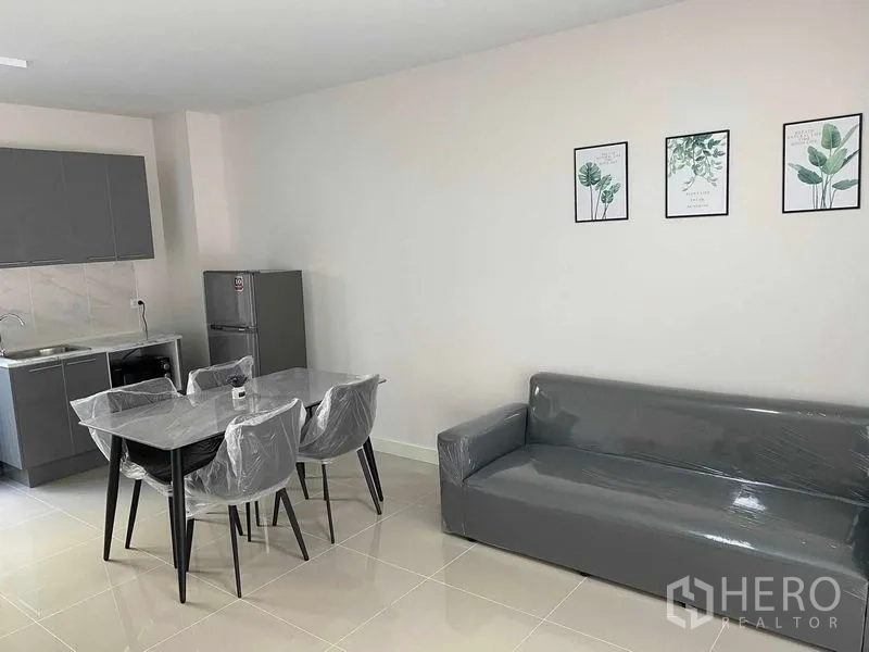 Townhouse for rent in Prawet, Bangkok - Another angle of the living-dining area with sofa, table and kitchenette.