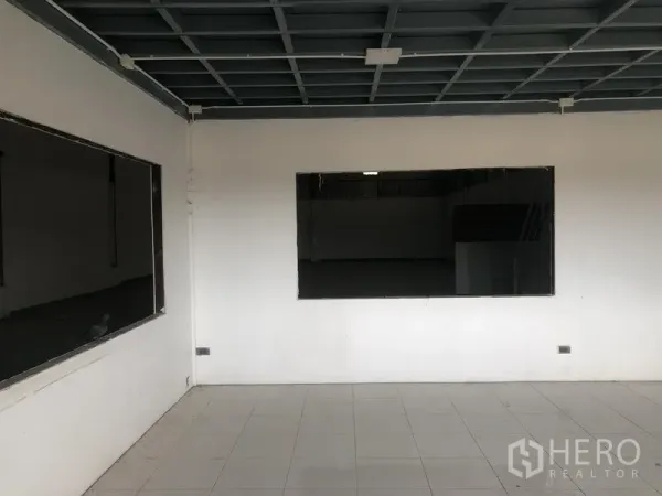 Factory for rent in Lat Lum Kaeo, Pathum Thani - Interior office room with tiled floor, large viewing windows and grid ceiling facing the factory floor.
