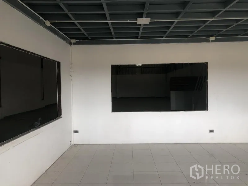 Factory for rent in Lat Lum Kaeo, Pathum Thani - Interior office room with tiled floor, large viewing windows and grid ceiling facing the factory floor.