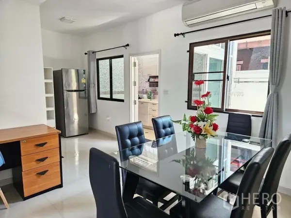 Townhouse for rent - Dining area with glass table, black chairs, wide windows, air conditioning and doorway to fitted kitchen.
