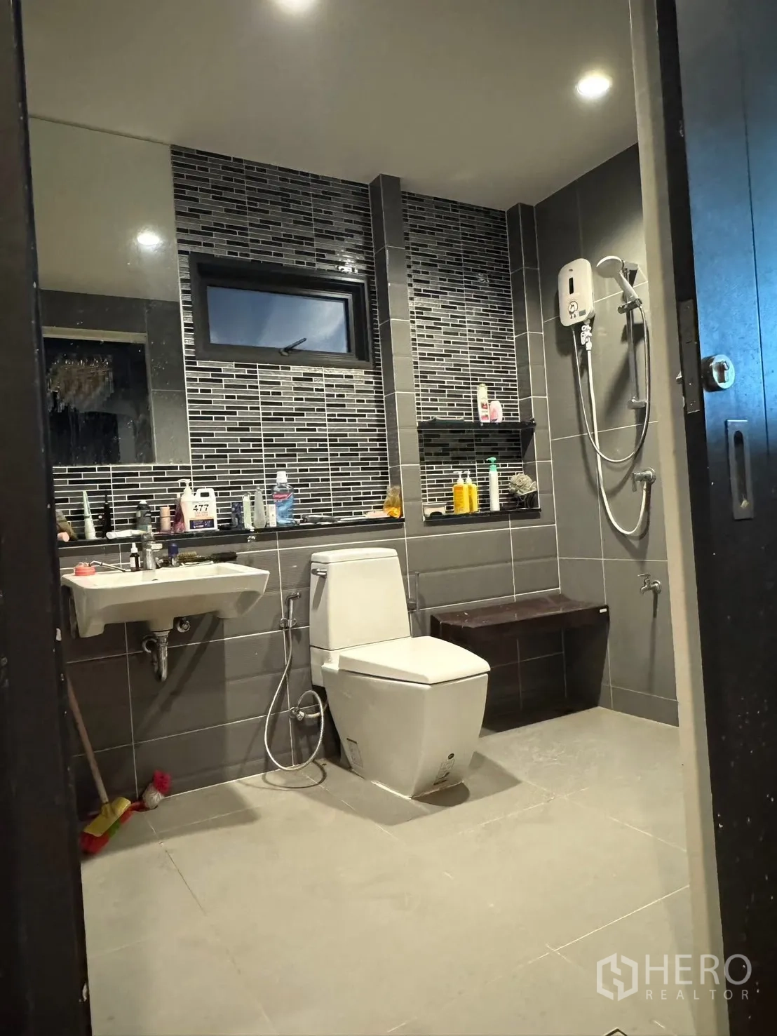 Detached House for sale in Mueang Pathum Thani, Pathum Thani - Bathroom with dark tiles, shower and small bench.