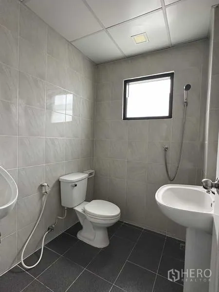 Warehouse for rent in Bang Phli, Samut Prakan - Clean tiled restroom with toilet, sink, and handheld shower in the warehouse office.