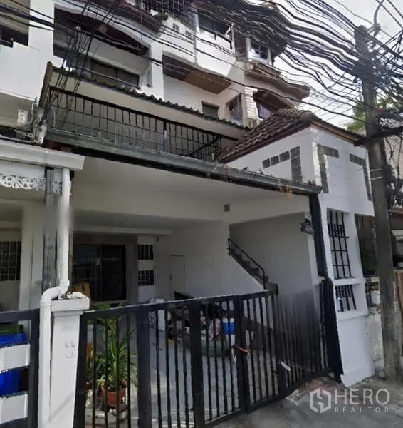 Home Office for rent in Khlong Toei, Bangkok - Front façade of the townhouse-style home office with black gate and covered parking.
