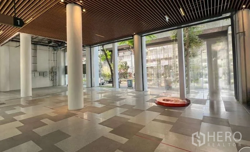 Retail Space for rent in Phaya Thai, Bangkok - Spacious corner retail space with patterned tile flooring, floor-to-ceiling windows, and building services ready for fit-out.