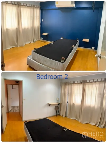 Townhouse for rent in Watthana, Bangkok - Second bedroom with blue feature wall, air-conditioning and warm wood floors.