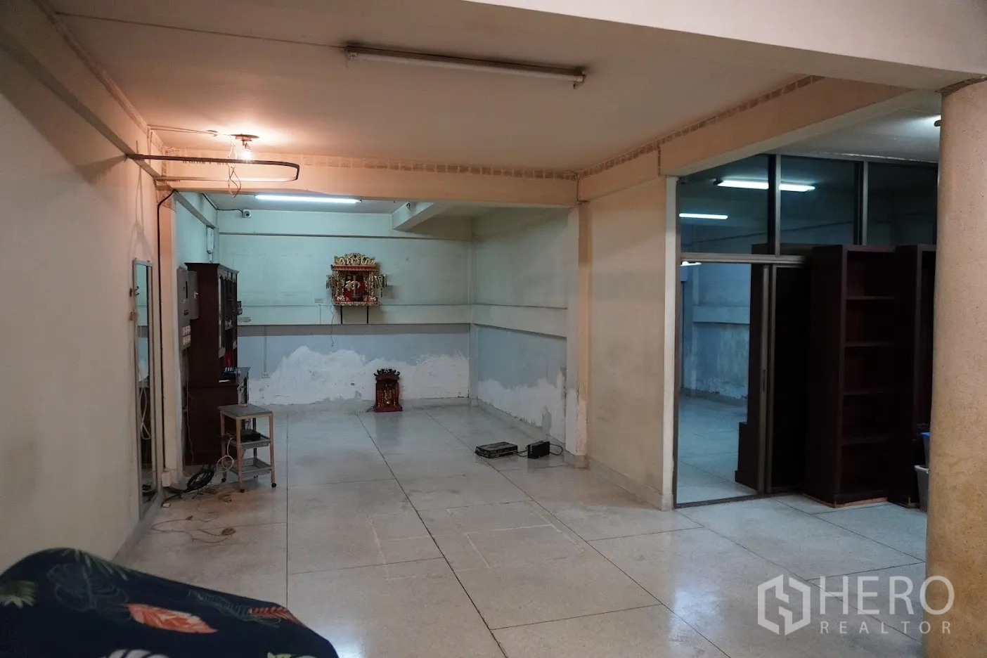 店屋 出租在Watthana, Bangkok - 一楼宽敞空间，瓷砖地面与玻璃隔间。