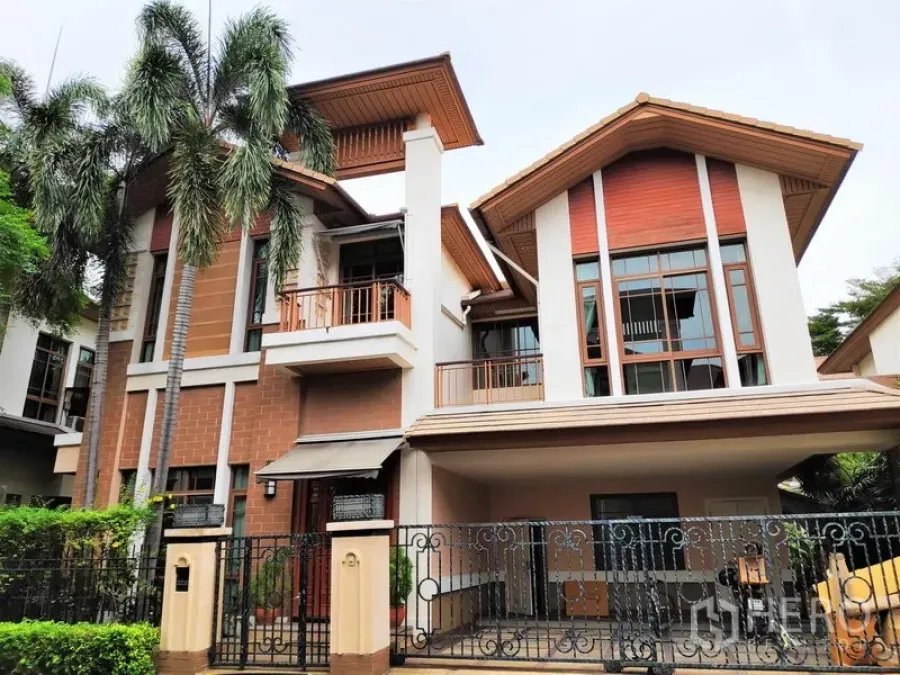Detached House for rent in Watthana, Bangkok - Contemporary three-storey detached house facade with balconies, large windows, a gated carport and tropical palms.