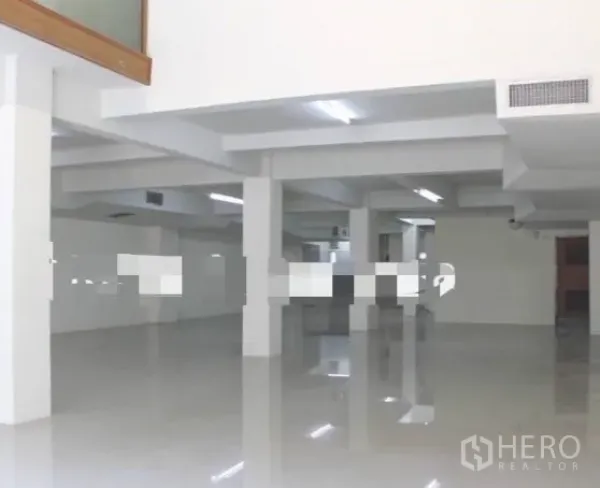 店屋 出租在Khlong Toei, Bangkok - 上层宽敞工作区，白色立柱、亮面地面与条形顶灯。