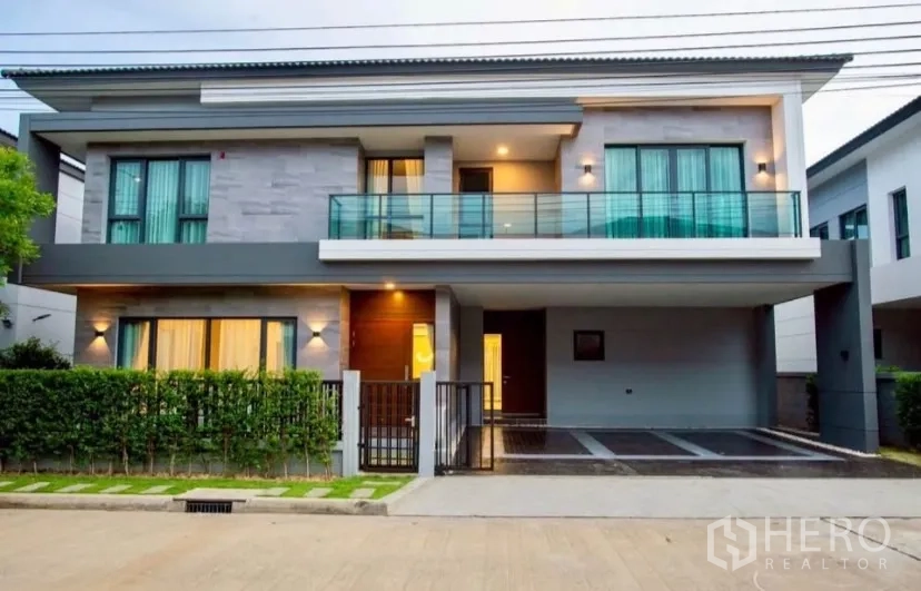 Detached House for rent in Bang Phli, Samut Prakan - Modern two-storey detached house facade with balcony, warm lights and covered driveway in Bang Phli.