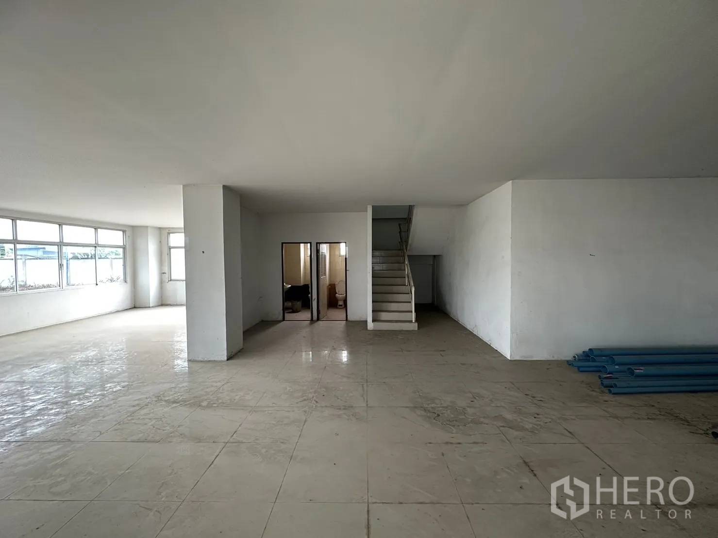 Factory for rent in Pak Kret, Nonthaburi - Office area with internal staircase, restrooms and large windows for natural light.