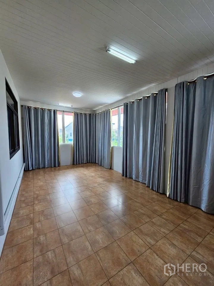 Home Office for rent in Wang Thonglang, Bangkok - Wide view of curtained tiled room with several windows and ceiling lights.