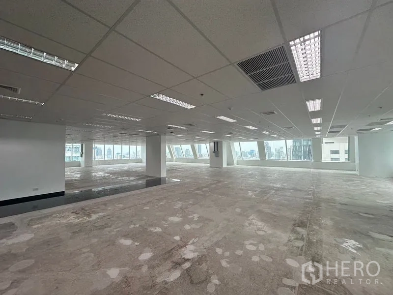 Office Space for rent - Long open‑plan aisle with windows at both ends and neutral finishes.