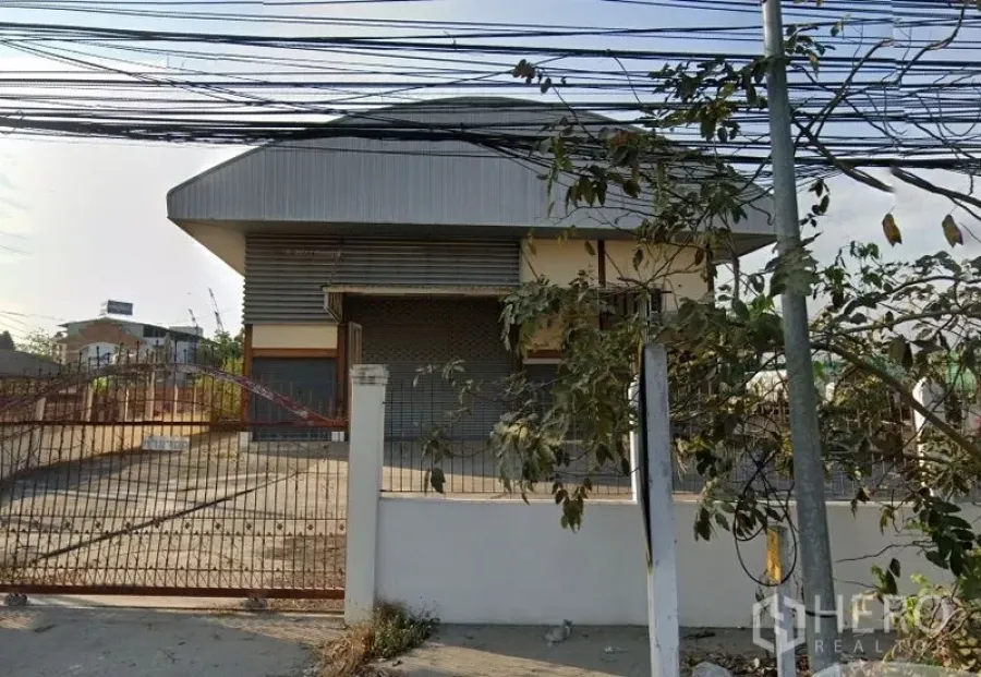 Warehouse for rent in Bang Phli, Samut Prakan - Gated entrance and roller shutter loading bay at an industrial warehouse in Bang Phli.
