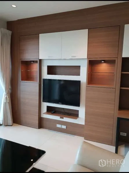Condominium for rent - Media wall in the living room with built-in cabinets, display niches and flat-screen TV.