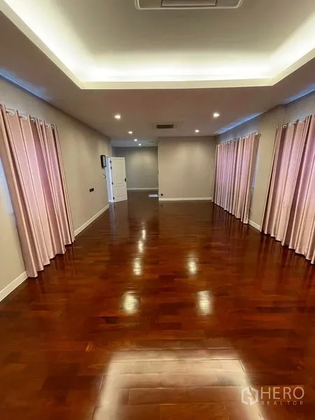 Detached House for sale in Mueang Samut Prakan, Samut Prakan - Large master bedroom with polished wooden flooring and recessed ceiling lighting.