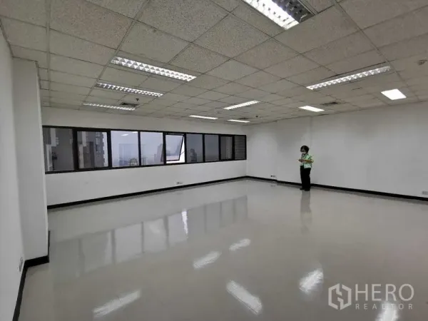 Office Space for rent in Watthana, Bangkok - Large office room with long windows providing city views and glossy floors.
