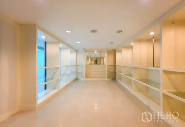 Office Space for rent in Khlong Toei, Bangkok - Long showroom with built-in shelving and recessed ceiling lights.