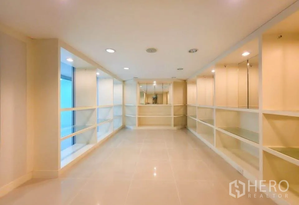 Office Space for rent in Khlong Toei, Bangkok - Long showroom with built-in shelving and recessed ceiling lights.