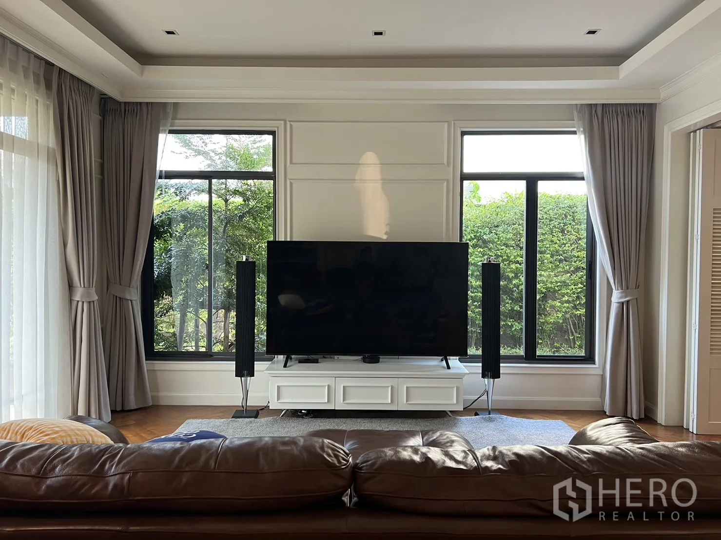 独立式住宅 出租在Suan Luang, Bangkok - 采光充足的客厅，大窗、窗帘和电视柜。