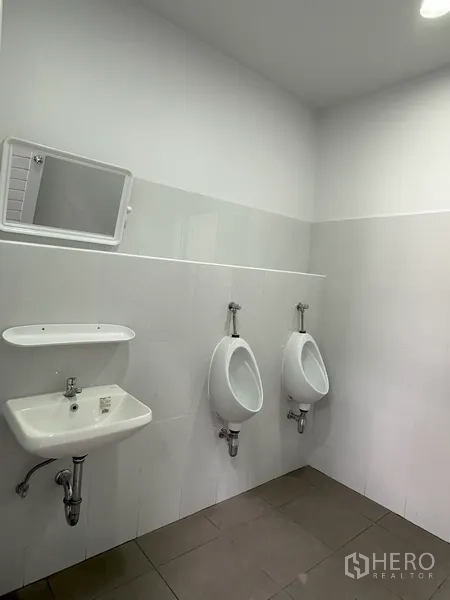 工厂 出租在Khlong Luang, Pathum Thani - 明亮瓷砖卫生间，配洗手盆与小便器。