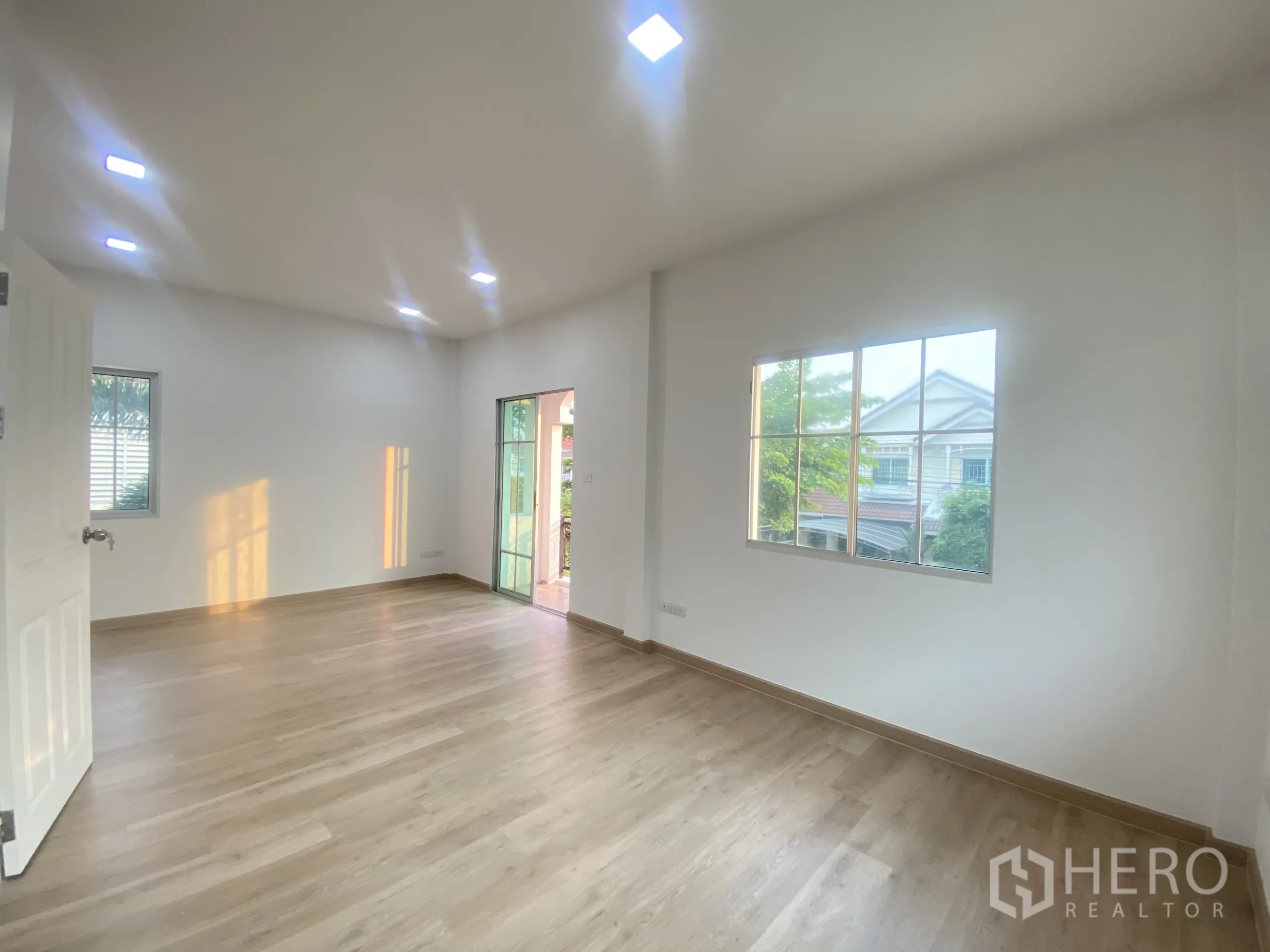 Detached House for sale in Nonthaburi - Balcony with wrought-iron railing overlooking a tree-lined residential street.