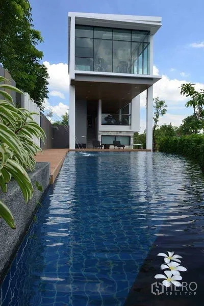 独立式住宅 出租或出售在Prawet, Bangkok - 社区公共泳池与玻璃幕墙会所。