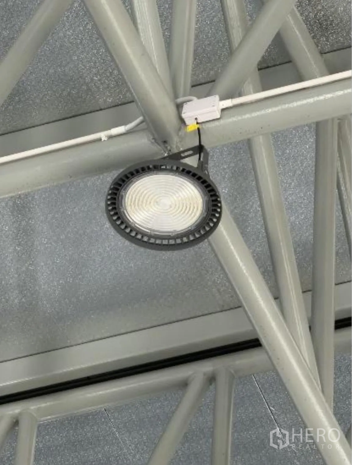 Warehouse for rent in Bang Khun Thian, Bangkok - Close-up of a high-bay LED light under the steel truss roof.