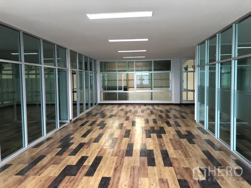 工厂 出租在Samut Prakan - 长走廊式办公区，整面玻璃墙与木纹地板。